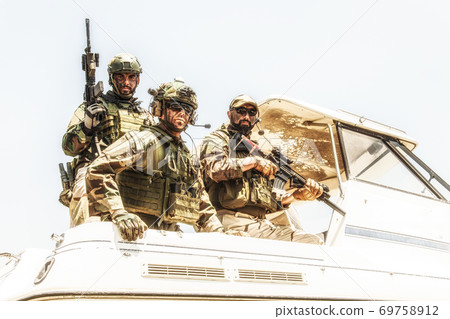 Army special forces soldiers on speed boat stern Army special forces soldiers on speed boat stern 69758912
