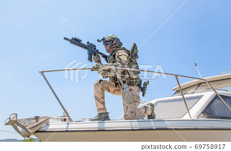 Army special forces soldier on speed boat bow Army special forces soldier on speed boat bow 69758917