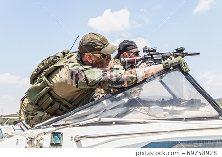 Navy SEALs soldiers chasing enemy on speed boat 69758928