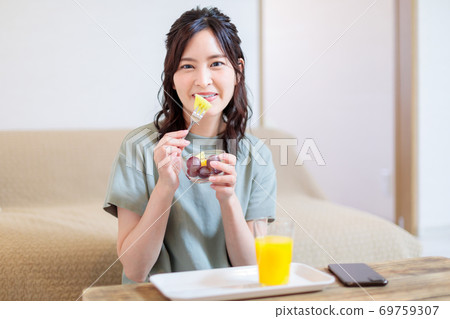 Woman eating fruit and relaxing Woman eating fruit and relaxing 69759307