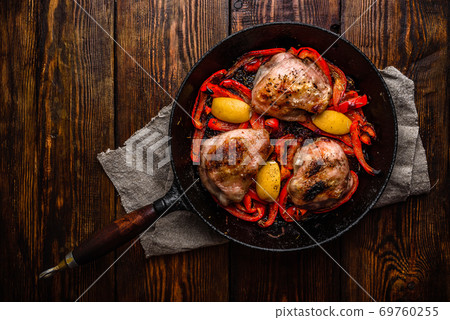 Chicken thighs with red bell peppers and lemon 69760255