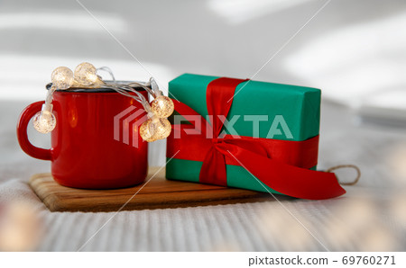 Red mug with garland and green Christmas gift Red mug with garland and green Christmas gift 69760271