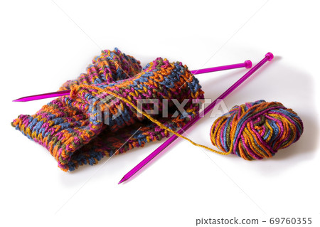 Top view of a colourful woolen cloth, needles and a skein isolated on white Top view of a colourful woolen cloth, needles and a skein isolated on white 69760355