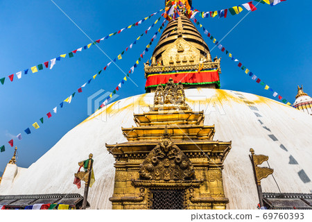 Tower of the Boudhanath Stupa decorated with flags in Kathmandu, Nepal. 69760393