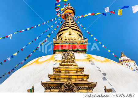 Tower of the Boudhanath Stupa decorated with flags in Kathmandu, Nepal. 69760397