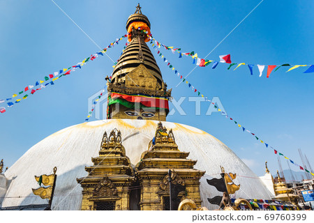 Tower of the Boudhanath Stupa decorated with flags in Kathmandu, Nepal. 69760399