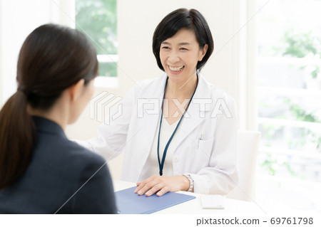 Business woman interviewing with a doctor Business woman interviewing with a doctor 69761798