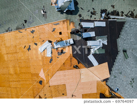 Roof construction repairman on a residential apartment with new roof shingle being applied 69764097