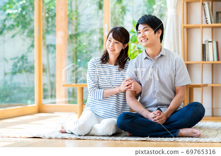一對年輕夫婦在客廳裡放鬆 一對年輕夫婦在客廳裡放鬆 69765316