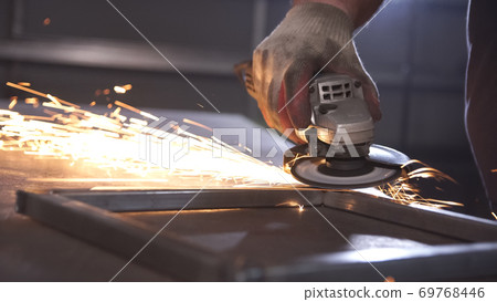 Polishing metal by machine in steel manufactory. Polishing metal by machine in steel manufactory. 69768446