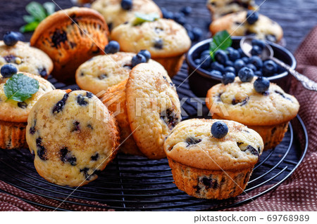 Blueberry muffins on a rustic wooden background Blueberry muffins on a rustic wooden background 69768989