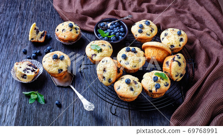 Blueberry muffins on a rustic wooden background Blueberry muffins on a rustic wooden background 69768991