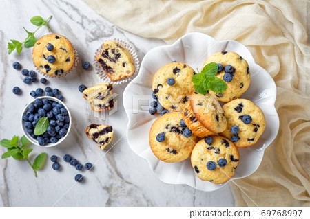Blueberry muffins on a white cake stand, close-up Blueberry muffins on a white cake stand, close-up 69768997