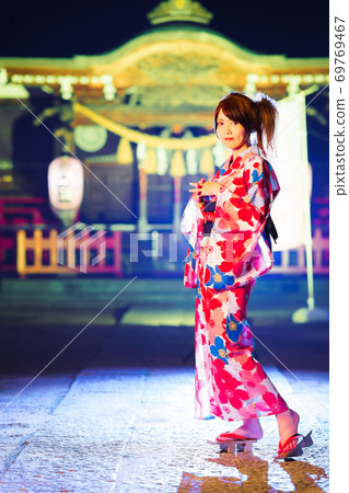 A young woman in a yukata at a shrine after the festival 69769467