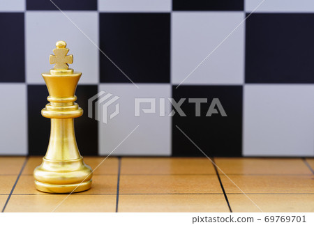 Gold king chess piece on wood chessboard 69769701