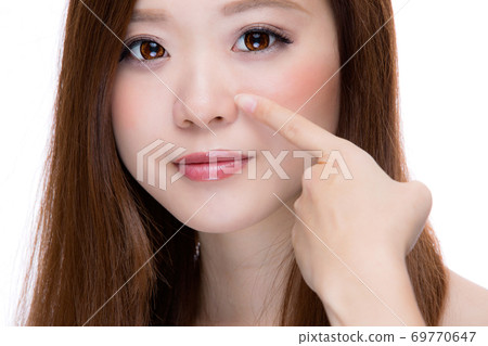 Woman pointing to nostril Woman pointing to nostril 69770647