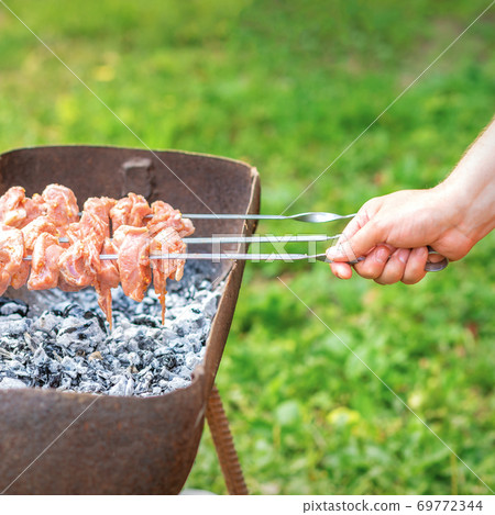 Hands of man prepares barbecue meat 69772344