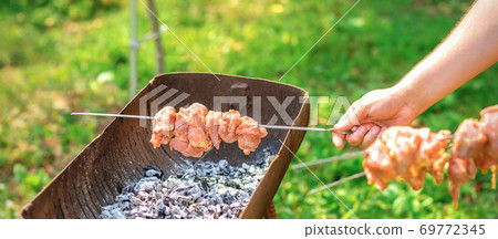 Hands of man prepares barbecue meat Hands of man prepares barbecue meat 69772345