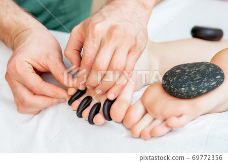 Hot little black stones between female toes Hot little black stones between female toes 69772356