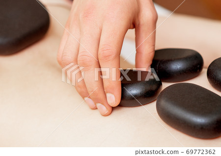 Massage stones on female back. Massage stones on female back. 69772362
