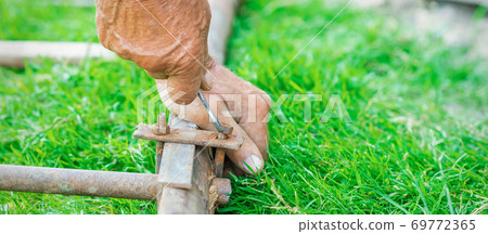 Elderly man twists the nut by wrench Elderly man twists the nut by wrench 69772365