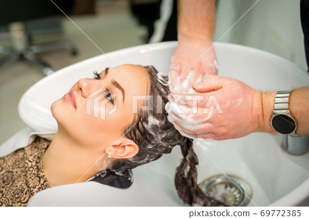 Young woman gets hair wash Young woman gets hair wash 69772385