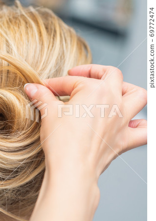 Hairstylist making bride wedding hairstyle 69772474