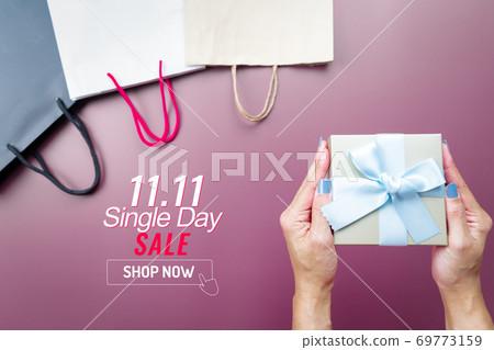 woman hand holding gift box and shopping bag for 11.11 single day sale woman hand holding gift box and shopping bag for 11.11 single day sale 69773159