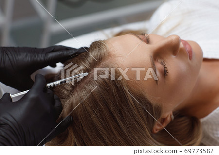 Doctor cosmetologist making mesotherapy injections in woman's head Doctor cosmetologist making mesotherapy injections in woman's head 69773582