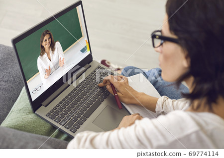 Student sitting at home, listening to online course, video conferencing and learning language. Online education. Student sitting at home, listening to online course, video conferencing and learning language. Online education. 69774114