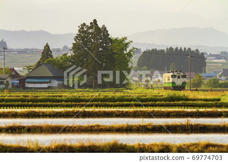 Tadami Line train running through the paddy fields at dusk, Aizumisato Town, Fukushima Prefecture Tadami Line train running through the paddy fields at dusk, Aizumisato Town, Fukushima Prefecture 69774703
