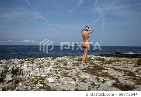Naked woman on the nudist beach 69775644
