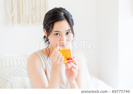 坐在床和微笑上的婦女 坐在床和微笑上的婦女 69775740