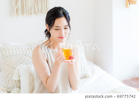 坐在床和微笑上的婦女 坐在床和微笑上的婦女 69775742