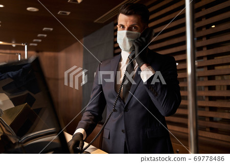 Confident receptionist being on the line during his working day 69778486