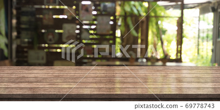 Empty wooden table top with lights bokeh on blur restaurant background, wood table banner Empty wooden table top with lights bokeh on blur restaurant background, wood table banner 69778743