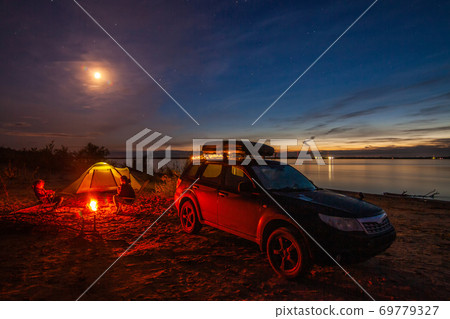 Girl and mom sitting at bonfire in tourist camping 69779327