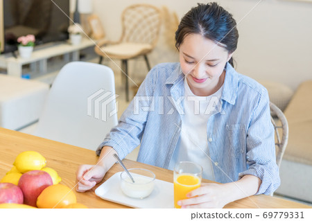 Young woman eating fruit Young woman eating fruit 69779331