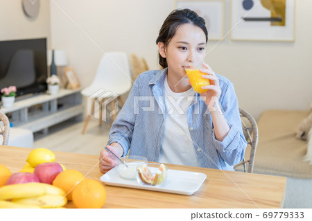 Young woman eating fruit Young woman eating fruit 69779333