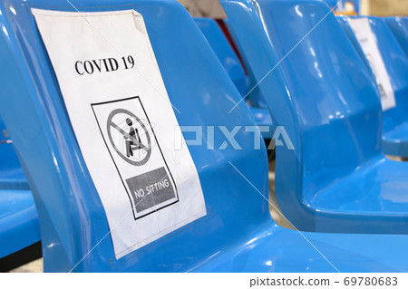 A empty seats at public area with a warning to keep the social distance, close up. A empty seats at public area with a warning to keep the social distance, close up. 69780683