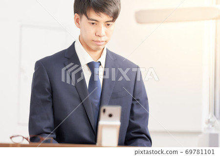Male student undergoing a remote interview on a smartphone 69781101