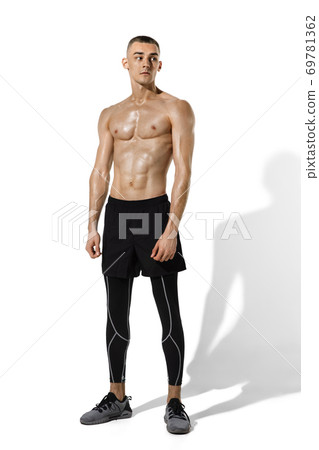 Beautiful young male athlete practicing on white studio background with shadows 69781362