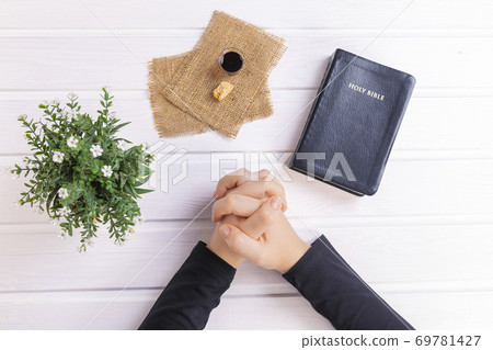 Young woman praying and Taking communion  - the wine and the bread symbols of Jesus Christ blood and body with Holy Bible 69781427