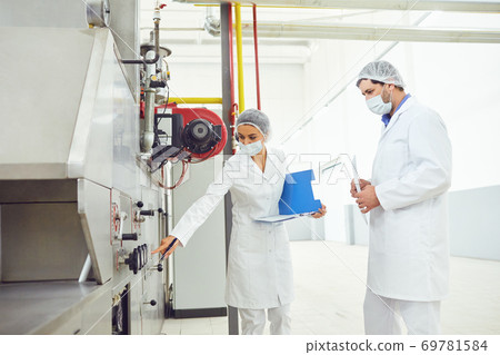 Two technologists at the food factory. 69781584