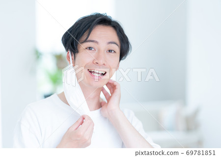 嘗試一個微笑的年輕人早晨戴上面具 69781851