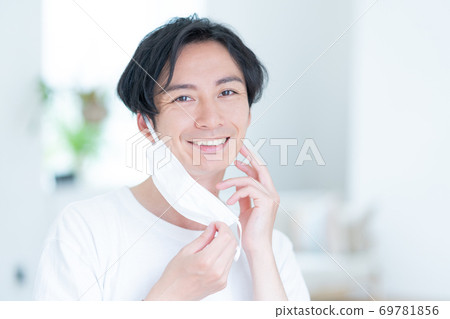 嘗試一個微笑的年輕人早晨戴上面具 69781856
