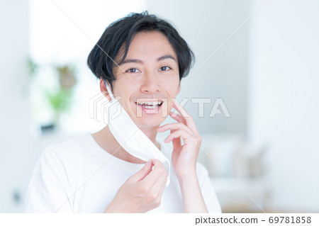 嘗試一個微笑的年輕人早晨戴上面具 69781858