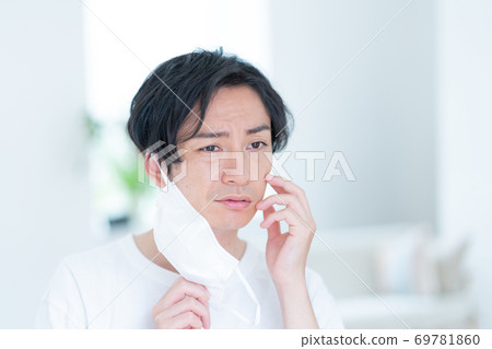 嘗試一個微笑的年輕人早晨戴上面具 69781860