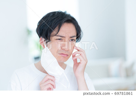 嘗試一個微笑的年輕人早晨戴上面具 69781861