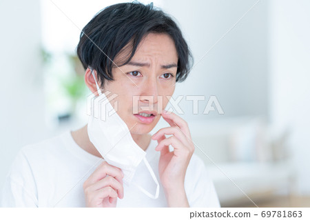 嘗試一個微笑的年輕人早晨戴上面具 69781863